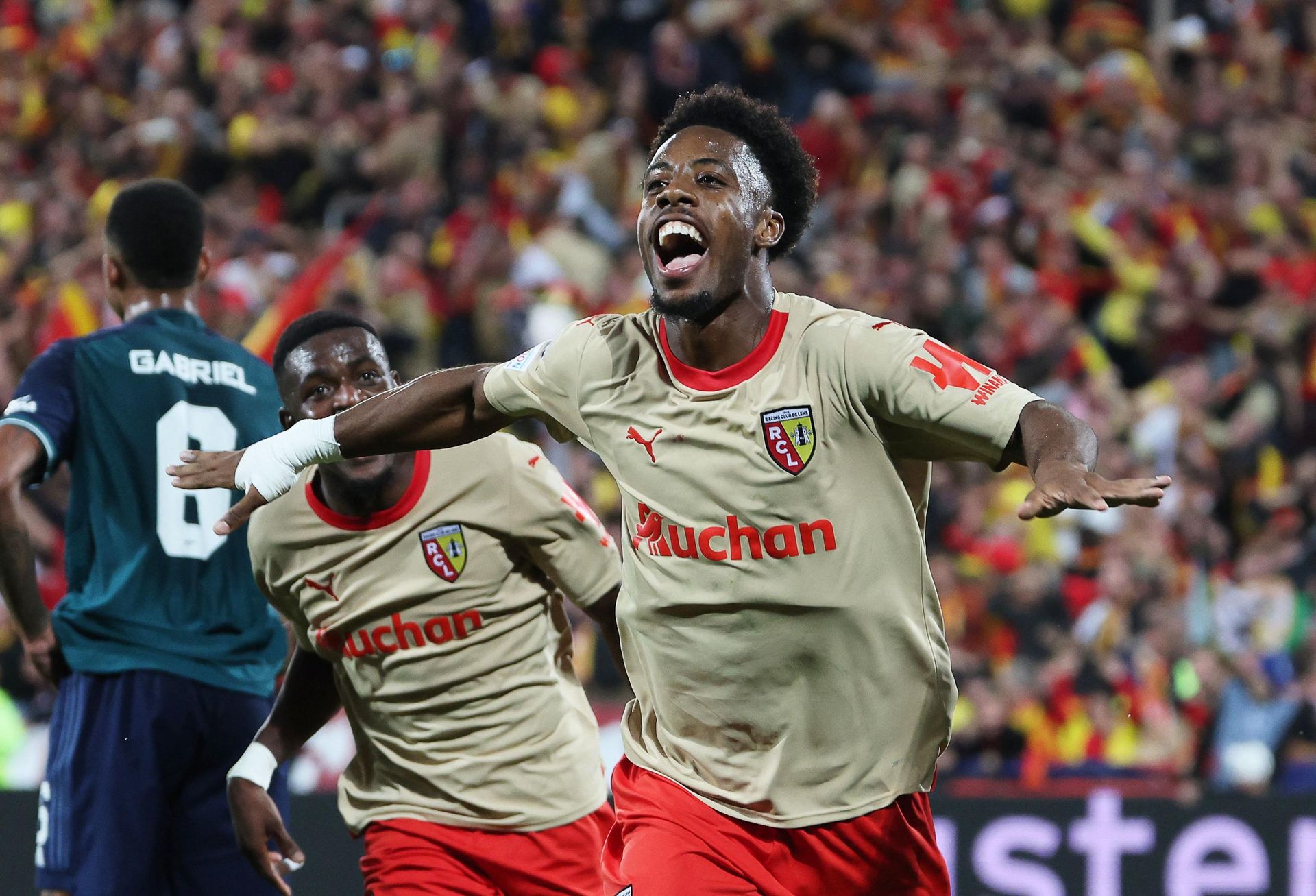 Les exploits réalisés par le RC Lens en finissant à deux reprises dauphin du PSG (2025/26, 2022/23) ou le Stade Brestois finissant 3ème lors de la saison 2023/24 montrent une réalité inquiétante. Bien que ces clubs viennent marquer l’histoire la Ligue 1, ils démontrent surtout une régression des gros clubs qui peinent en Ligue 1 face à des adversaires plus “petits” et qui ne sont pas armés pour venir affronter des clubs étrangers.(Elye Wahi lors de la saison 2023-2024 célébrant son but face à Arsenal © Denis Charlet/ AFP)